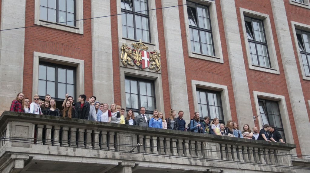 Bürgermeister Reiner Breuer zeigt den Schülerinnen und Schülern aus Warschau Neuss vom Rathausbalkon.