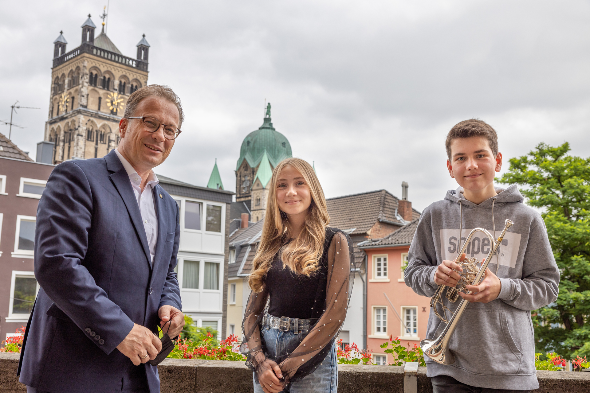Bürgermeister Breuer und die beiden Preisträger von Jugend Musiziert auf dem Rathausbalkon