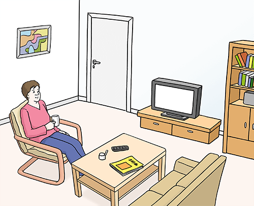 Frau sitzt im Wohnzimmer.